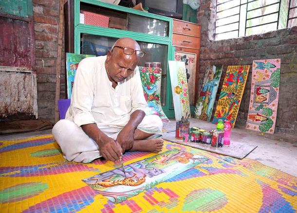Dhirendra Chandra is painting in Rickshaw's back board