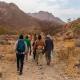 Photo of workshop participants walking in dramatic red mountainous landscape Africa’ workshop
