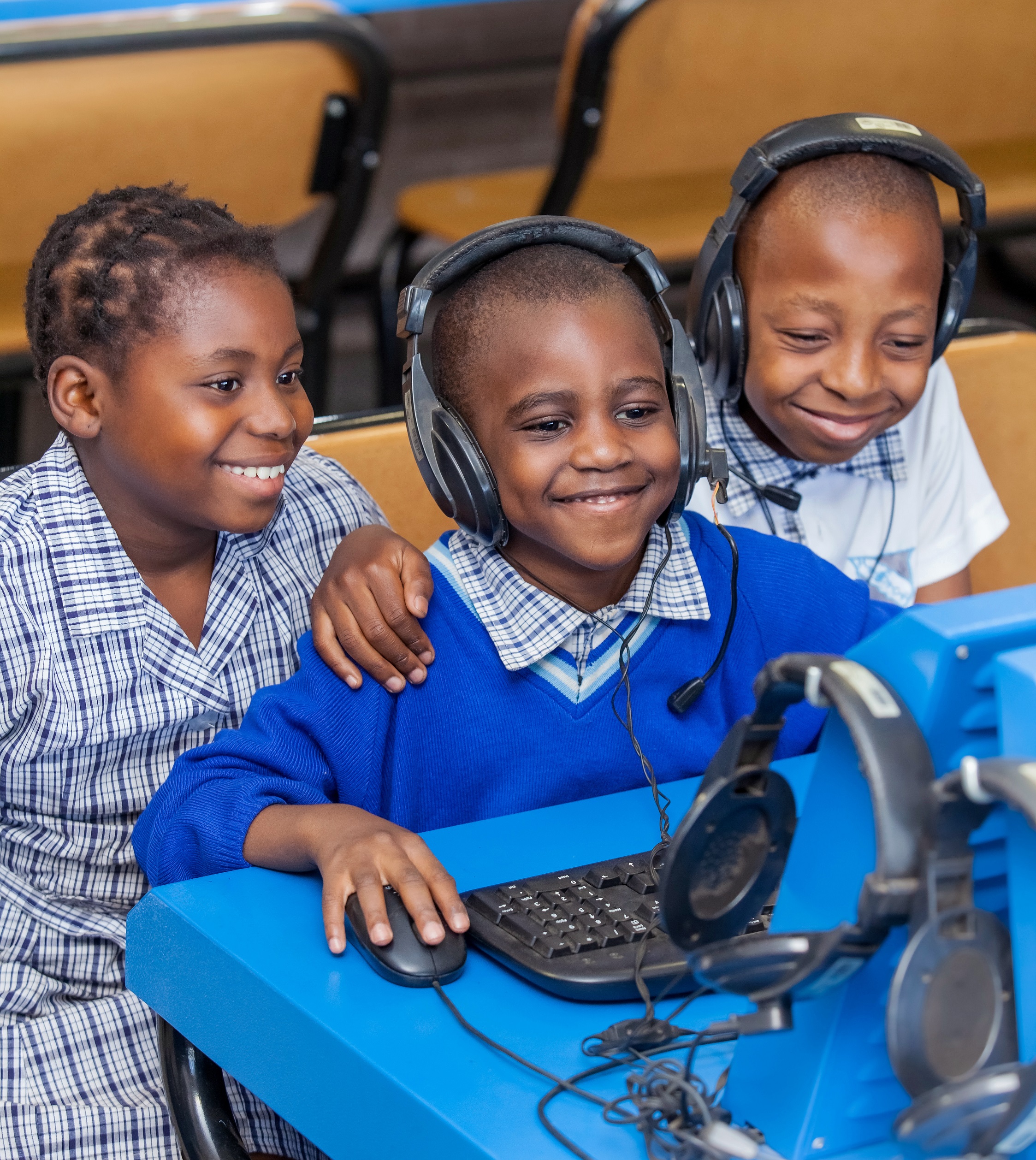 Children looking at computer in school classroom room in Africa.