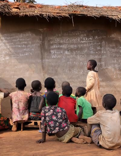 NTCHISI, MALAWI - JUNE 30, 2018: Unidentified students study in front of a small school building in a remote village near Ntchisi. Malawi is one of the poorest countries in the world.