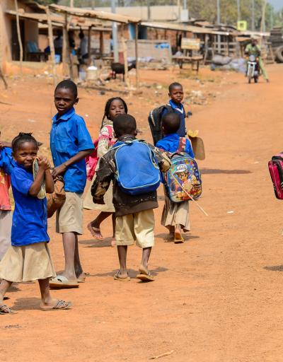 PIRA, BENIN - JAN 12, 2017: Unidentified Beninese children in school uniform go in the street. Benin kids suffer of poverty due to the bad economy.