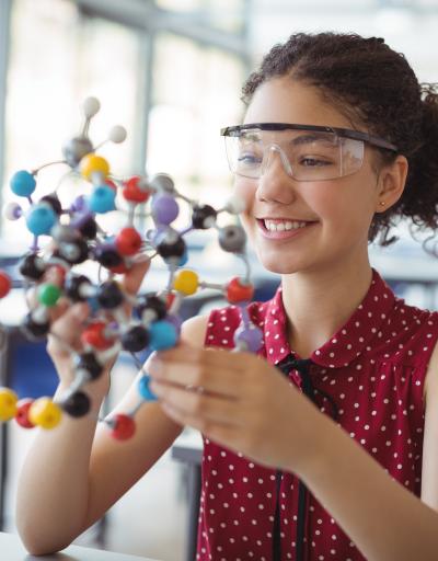 young girl learning with a molecular model
