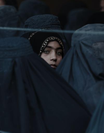 A Girl Looks on Among Afghan Women Lining Up To Receive Relief Assistance, During The Holy Month of Ramadan in Jalalabad, Afghanistan.