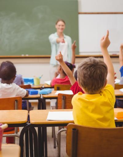 Kids in school raising hands education response