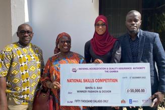 Binta, second to the right, proudly presenting her award with her brother (far right) and training center CEO and teacher (left)
