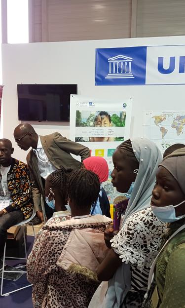 Abou Amani explains to a group of schoolchildren why it is so important to take good care of water, at the UNESCO pavilion during the World Water Forum in Dakar, Senegal, in March 2022