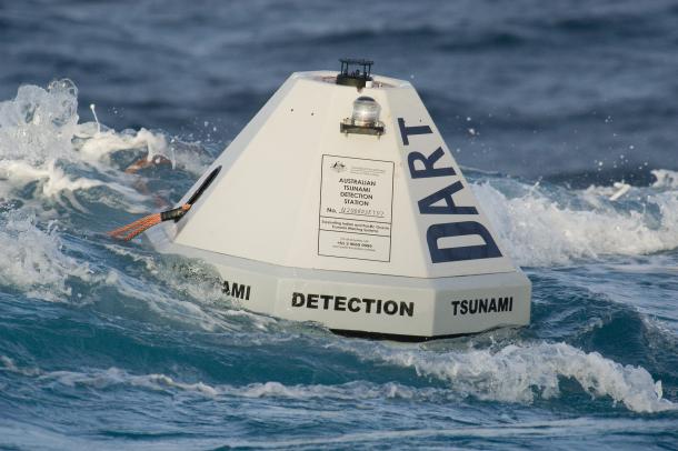 A DART (Deep-ocean Assessment and Reporting of Tsunamis) buoy floating on the ocean surface. The buoy is tethered to a tsunameter on the ocean floor.