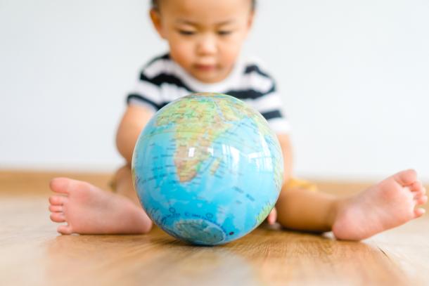 a toddler looking at a globe
