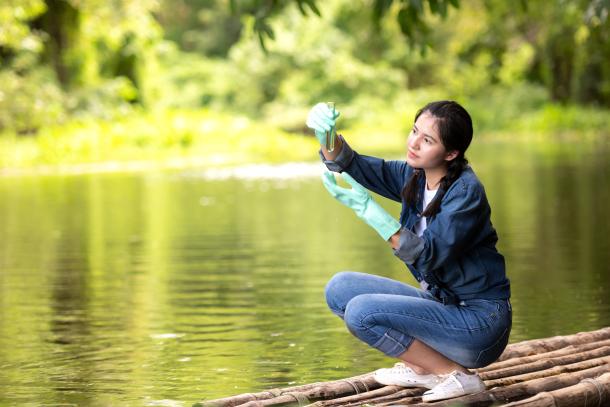 scientist collecting a water sample for analysis