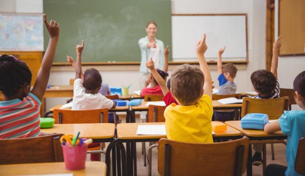 Kids in school raising hands education response