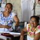 Artesanas de Maní, Yucatán, sonriendo hacia la cámara. En medio de ellas una máquina de coser.